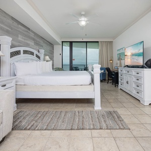Unwind in the master suite featuring a comfortable king bed, stylish decor, and access to the beachfront balcony
