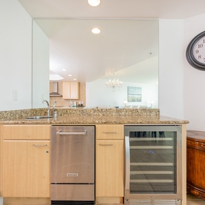 Stylish wet bar featuring sleek stainless appliances and a stylish granite countertop, perfect for culinary adventures
