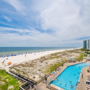 Relax on the balcony with seating that offers views of the gradual entry pool and the beach beyond