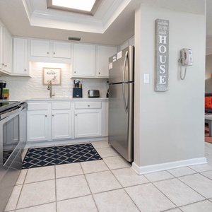 The modern kitchen features stainless appliances, Keurig and coffee maker, and a bright, airy design with white cabinetry