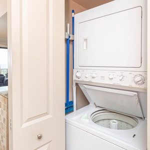 This laundry area features a stacked washer and dryer, conveniently located near the living space for easy access