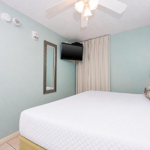 Relax in this comfortable bedroom with a plush king bed, a TV, and soothing colors for a restful night's sleep