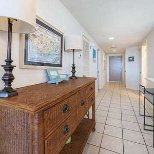 Step into a welcoming entryway featuring a stylish console table, decorative lamps, and a vibrant coastal map