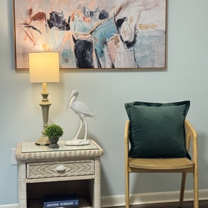 Relax in a charming corner with a cozy chair, stylish lamp, and decorative art for a peaceful reading nook