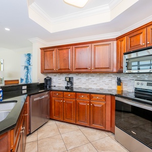 This kitchen features a Keurig and a coffee maker, stylish backsplash, and casual bar seating for waking up to a morning cup