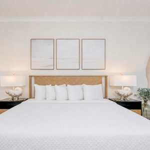 Relax in this guest bedroom featuring a plush king bed, decorative art, and stylish lamps for a restful vibe