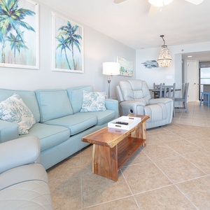 Comfortable seating, a rustic wood coffee table, and cheerful decor create a relaxed vibe in this inviting living area
