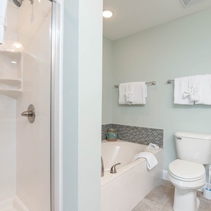 Indulge in a soothing soak in the inviting tub or rinse in the shower, surrounded by calming decor for ultimate relaxation