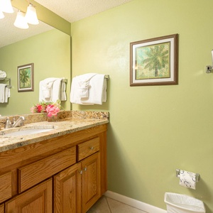 Discover the guest bathroom with a spacious vanity, stylish decor, and fresh towels for your convenience