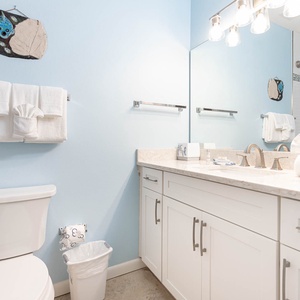 Refresh in this guest bathroom featuring a double vanity, soft towels, and cheerful coastal decor