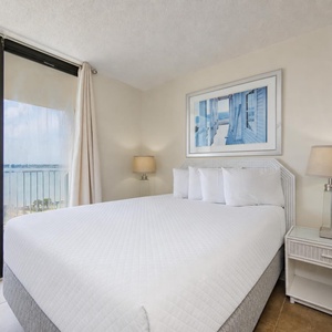 Enjoy serene lagoon views from the queen master suite, enveloped in soft bedding, for a restful night's sleep