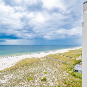 Stunning view showcasing the beach, sunbathers, and vibrant umbrellas against a backdrop of calm gulf waters