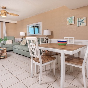 This living area features a comfortable green sofa with queen sleeper, a stylish wooden dining table, and a captivating view
