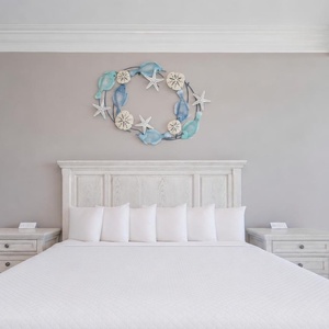 Relax in this serene master bedroom featuring a king bed, decorative accents, and beachfront balcony access