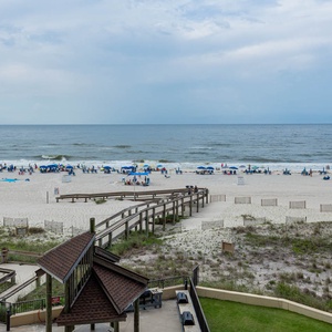 Experience the serene beach view with beachgoers enjoying the sandy shore and gentle waves