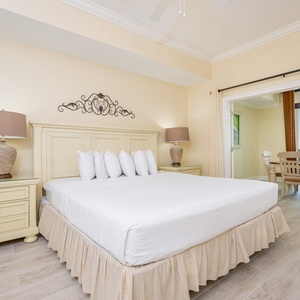 Relaxing master bedroom featuring a plush king bed and access to a dining area with a scenic view