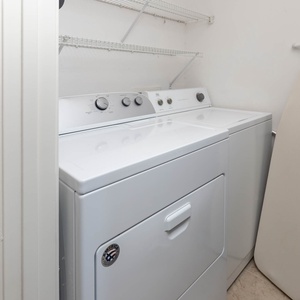 The laundry area features a washer and dryer, with a convenient ironing board nearby for added guest convenience