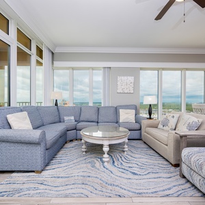 Unwind in the inviting living area, where plush seating and panoramic coast views create a serene escape