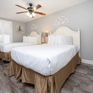 Unwind in this inviting guest bedroom featuring two double beds, soft linens, and tasteful decor for a restful stay