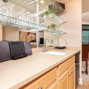 Grab a chilled drink or create a cocktail at this sleek wet bar with an elegant glassware display