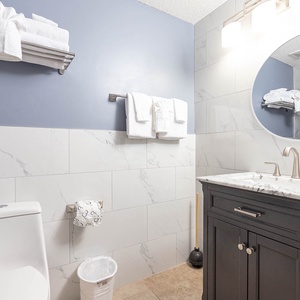 Enjoy the sleek guest bathroom with a stylish vanity, modern fixtures, and fresh towels for your convenience