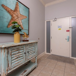 Step into a vibrant entryway adorned with beach-inspired decor, setting a cheerful tone for your getaway