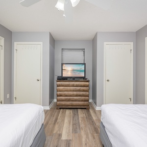 Enjoy restful nights in this inviting guest bedroom with two double beds, a TV, and easy access to the bathroom