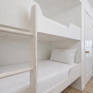 This cozy space features a bunk bed and a view of the beach, with a bright living area just steps away
