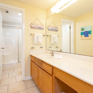 Enjoy the master bathroom featuring a spacious vanity, cheerful decor, and a walk-in shower for your convenience