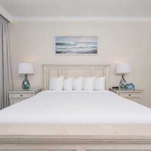 Retreat to this serene master bedroom featuring a king bed, soft linens, and calming coastal decor