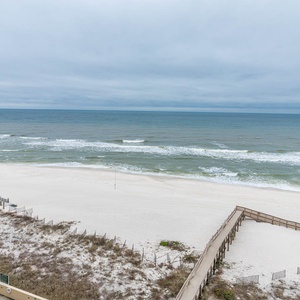 Breathtaking view of the serene beach and gentle waves from a cozy balcony, perfect for relaxation and seaside enjoyment