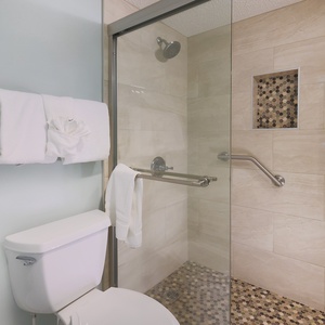 Refresh in this master bathroom, featuring a spacious walk-in shower with elegant tile work and plush towels