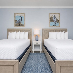 Rest comfortably in this dual queen guest room with soft pillows and coastal accents
