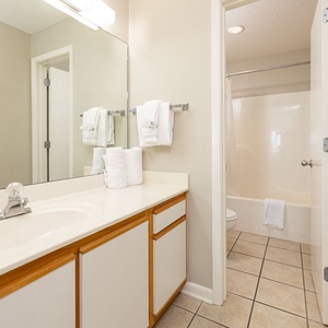 Refresh in the bathroom featuring a spacious vanity, ample towels, and a relaxing tub for your convenience