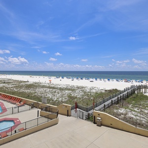Vibrant beachfront view with the pool area and colorful umbrellas dotting the white sand beach