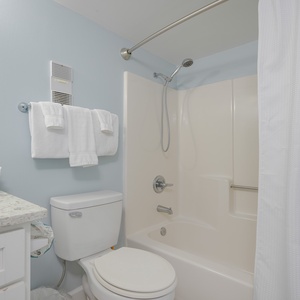Refresh and invigorate in the guest bathroom, featuring plush towels and a soothing shower experience