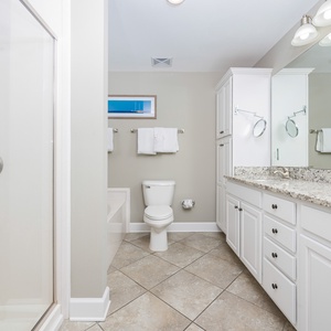 Refresh in the master bath after a day at the beach with a soothing tub and relaxing walk-in shower