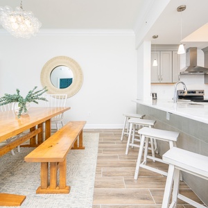 Gather around the large wooden dining table, complemented by stylish decor, perfect for meals and shared moments