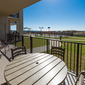 Enjoy meals or drinks at the round table on your balcony, with views of the grassy area and nearby splash park