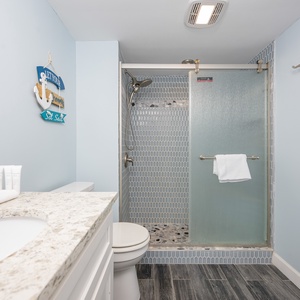 Indulge in a refreshing shower experience while enjoying a modern design and beachy vibe in the master bath