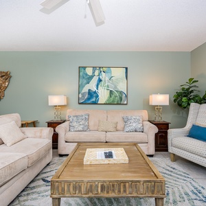 Unwind in the inviting living area, featuring plush seating, vibrant artwork, and sofa with queen sleeper
