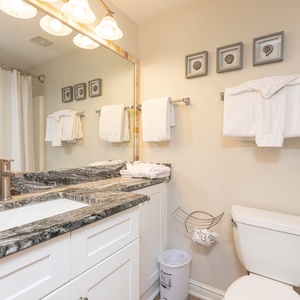 Brightly lit guest bathroom featuring a spacious countertop, modern fixtures, and fresh towels for a relaxing retreat