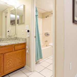 Master bathroom featuring a granite countertop, a tub/shower combo, and a large mirror reflecting the space