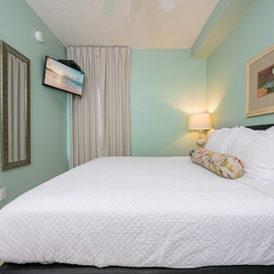 Enjoy restful nights in this inviting bedroom with a plush king bed, soft colors, and a TV for your entertainment
