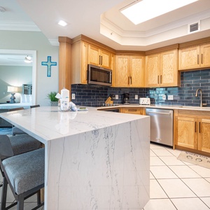 Prepare meals in this kitchen with elegant cabinetry, stainless appliances, and stylish backsplash