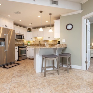 Bright kitchen features granite countertops, a breakfast bar, and stainless appliances, creating a welcoming space for meals