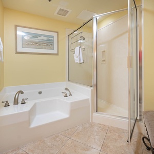 Indulge in relaxation with a spacious jetted tub and separate walk-in shower, complemented by warm yellow walls