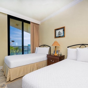 Wake to a breathtaking sunrise in this twin guest suite with two cozy beds and expansive views from the windows
