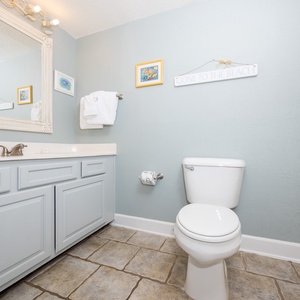 Light blue walls and a large mirror complement the stylish vanity with ample counter space in this inviting guest bathroom
