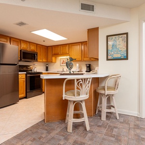 Cook and gather at the breakfast bar, featuring stylish seating and a view into the inviting kitchen space